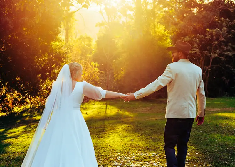 Amanda and Gareth standing in the lush green grounds of Riverwood Downs for their wedding