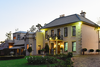 Lauren and Wes posing in front of the historic facade of Eschol Park House wedding venue