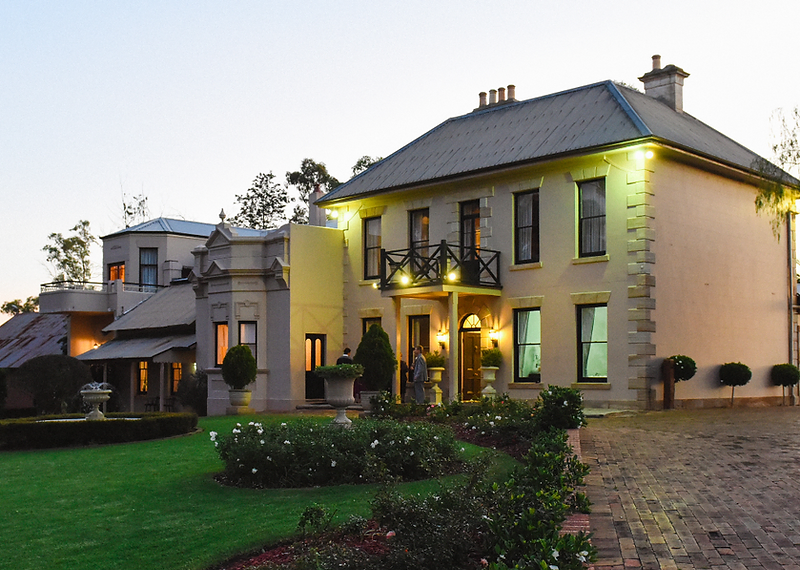 Lauren and Wes posing in front of the historic facade of Eschol Park House wedding venue