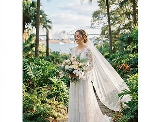 Sydney wedding photography — a bride in a white lace dress with a flowing veil among lush palms and foliage in the Royal Botanic Garden Sydney