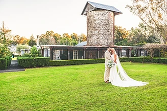 Tina and Izzy embracing at their rustic country wedding at The Homestead in Berry NSW