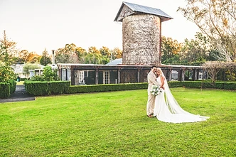 Tina and Izzy embracing at their rustic country wedding at The Homestead in Berry NSW