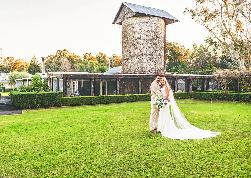 Tina and Izzy embracing at their rustic country wedding at The Homestead in Berry NSW