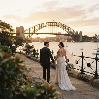 Sydney wedding photography — a couple walking along a Sydney foreshore promenade with the Sydney Harbour Bridge spanning the harbour at golden hour