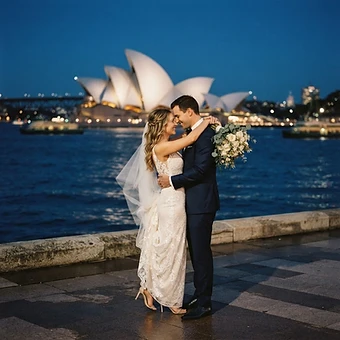 Sydney wedding photography — a couple embracing with the Sydney Opera House sails glowing at blue hour over Sydney Harbour