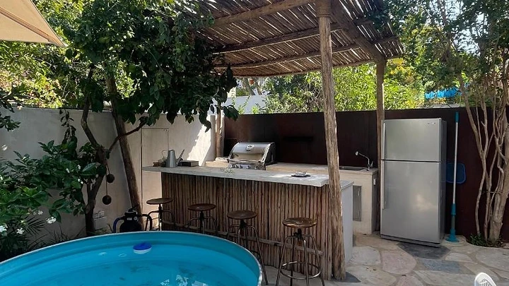 הקמת גינה פרטית מעוצבת באשדוד עם פרגולת עץ וצמחייה - פאפאיה נוף