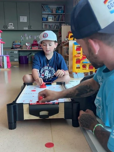 Carter playing air hockey with his dad