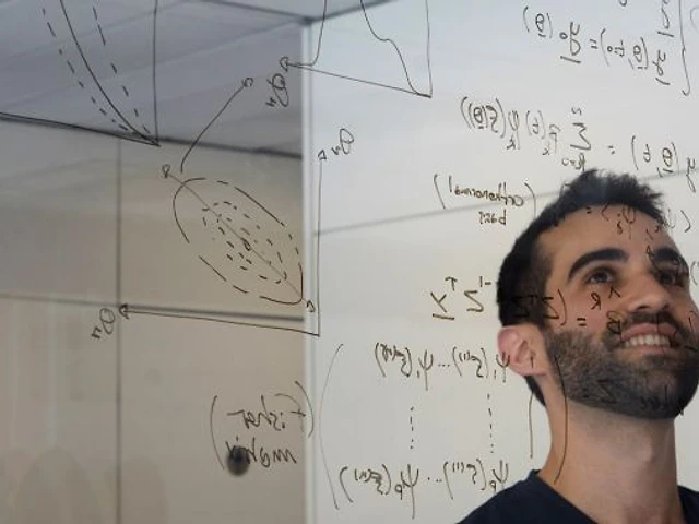 A Nova scientist working through mechanistic model equations on a glass whiteboard