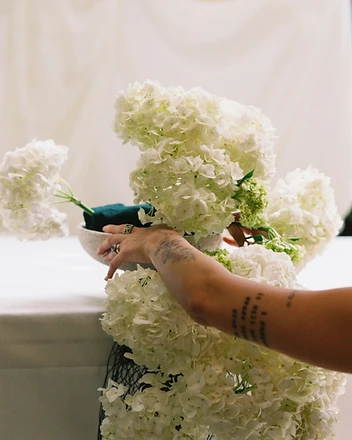 Another angle of couple at sweetheart table with hydrangea display