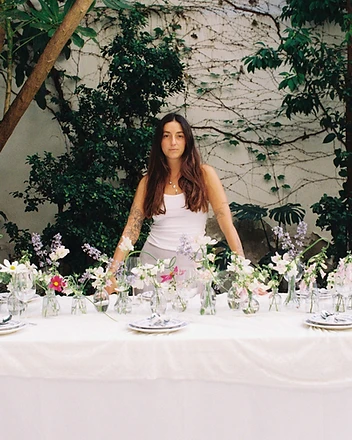 Florist standing behind beautifully set garden table