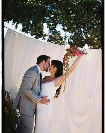 Bride laughing, holding her bouquet aloft