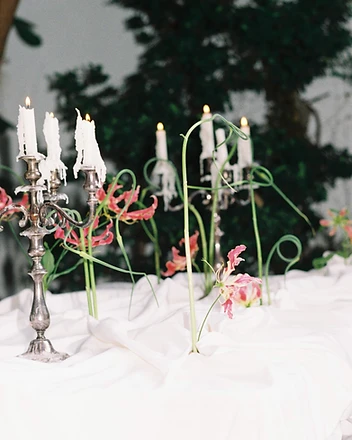 Table set with bud vases of wildflowers in glass bottles