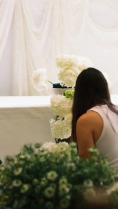 Couple holding hands at sweetheart table beside hydrangeas