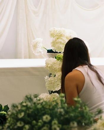 Couple holding hands at sweetheart table beside hydrangeas