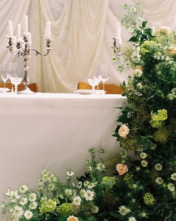 Sweetheart table with large green and ivory floral column