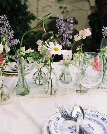 Cosmos and foxglove stems in clear glass bud vases