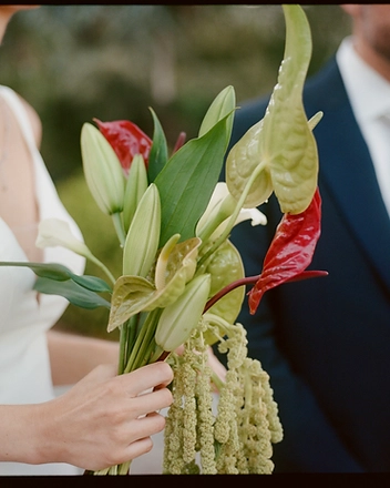 Close-up of the bridal bouquet with the groom behind