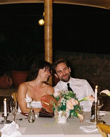 Bride and groom laughing together at the candlelit table