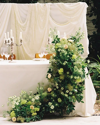 Sweetheart table with cascading green floral arrangement outdoors