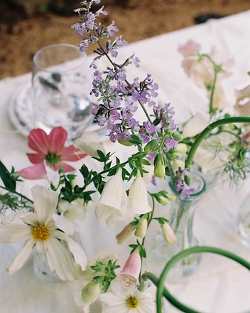 Florist preparing hydrangea arrangement beside draped table