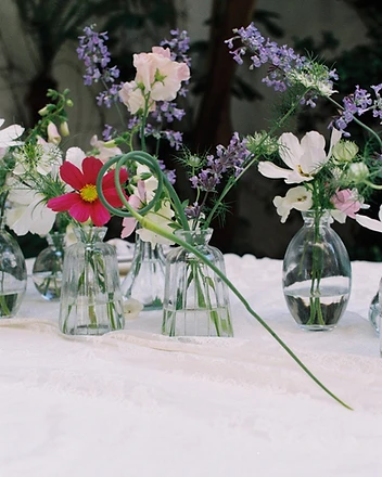 Afternoon garden table with floral runner of bud vases