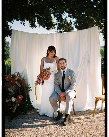 Bride and groom beneath a draped fabric backdrop