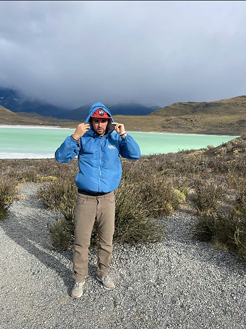 Hiker beside a turquoise Patagonian lake