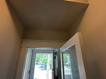 Water-damaged entryway ceiling rebuilt and repainted — after
