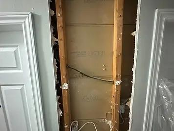 Bedroom wall opened for a leak, patched and repainted — before