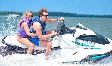 Clearwater Beach jet ski island tour — couple riding together and smiling at the camera