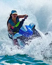 Clearwater Beach jet ski island tour — woman leaning into a turn with a dramatic splash