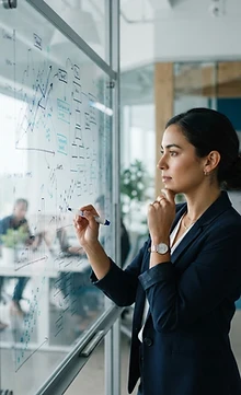 Analyst reviewing data and charts on a glass whiteboard