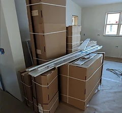 Large haul of boxed furniture items stacked in a room