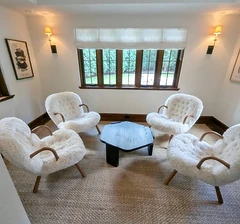 Set of four fluffy white armchairs arranged in a room