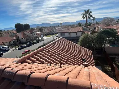 Completed terracotta barrel-tile roof with aligned courses, hips, and ridge tiles.