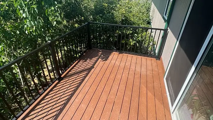 Composite balcony deck with black metal railing