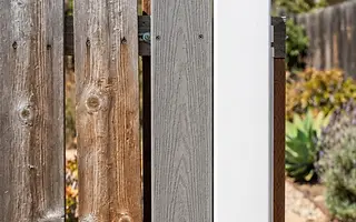 Editorial illustration: Weathered redwood, gray composite and white vinyl fence panels side by side under direct California sun