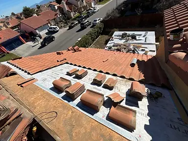 Barrel roof tiles being relaid over a new high-temperature underlayment system.