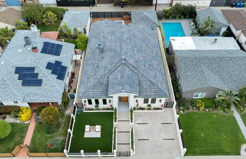Aerial view of a completed Valley Glen home showing the full shingle roof, ridge lines, vents, and surrounding property.