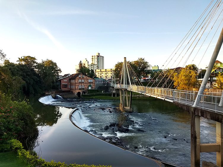 Rio com ponte pênsil e casa enxaimel em Timbó, Santa Catarina