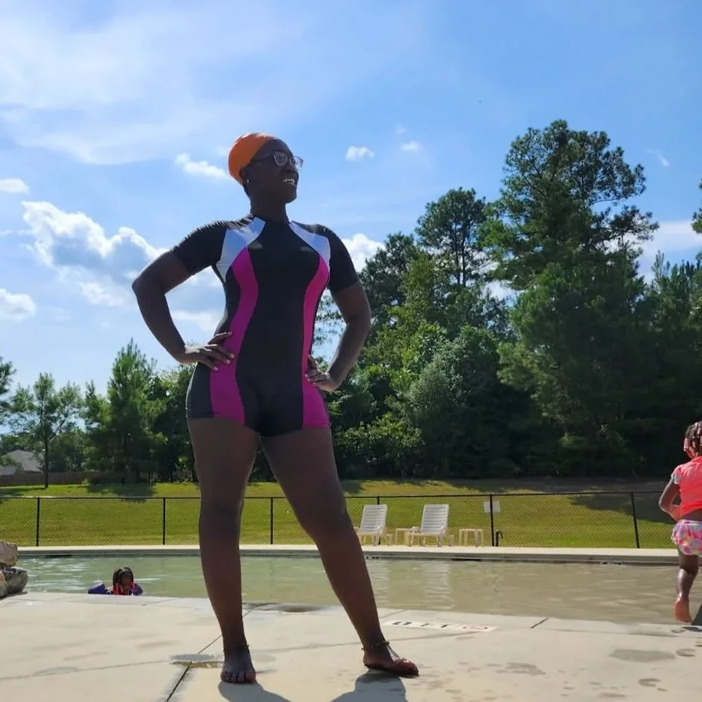 An instructor warmly guiding a young swimmer in the pool