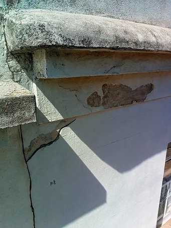 Significant cracking across upper facade panel — delamination evident