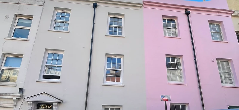 Completed render redecoration — 58 Brunswick Street West in off-white with pink door, 60 in pink masonry paint