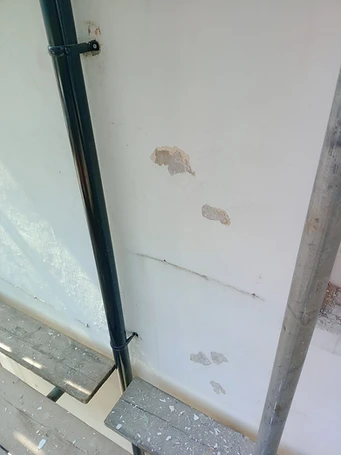 Render surface showing delamination and moisture ingress around window cill