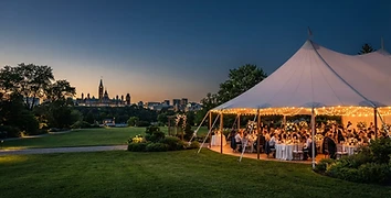 Sailcloth pole tent at twilight with warm interior lighting at an Ottawa event venue