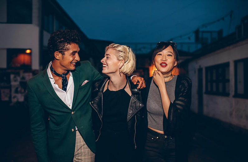 Three friends laughing together on a night out in the city