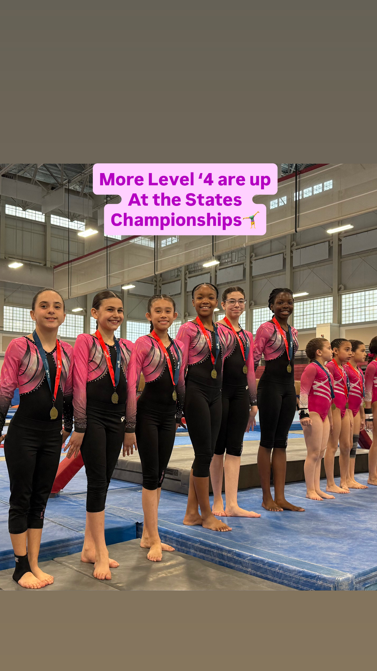 Gymnasts on competition podium with hands raised