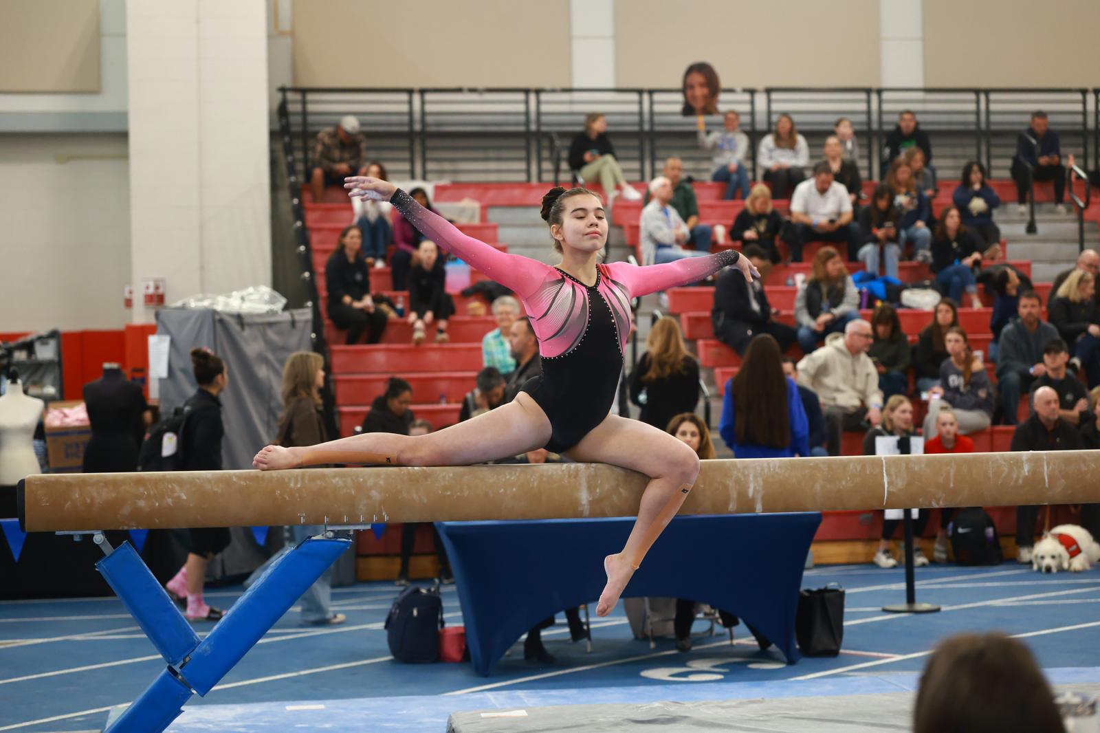 Gymnast with gold medal placing hand over heart at competition