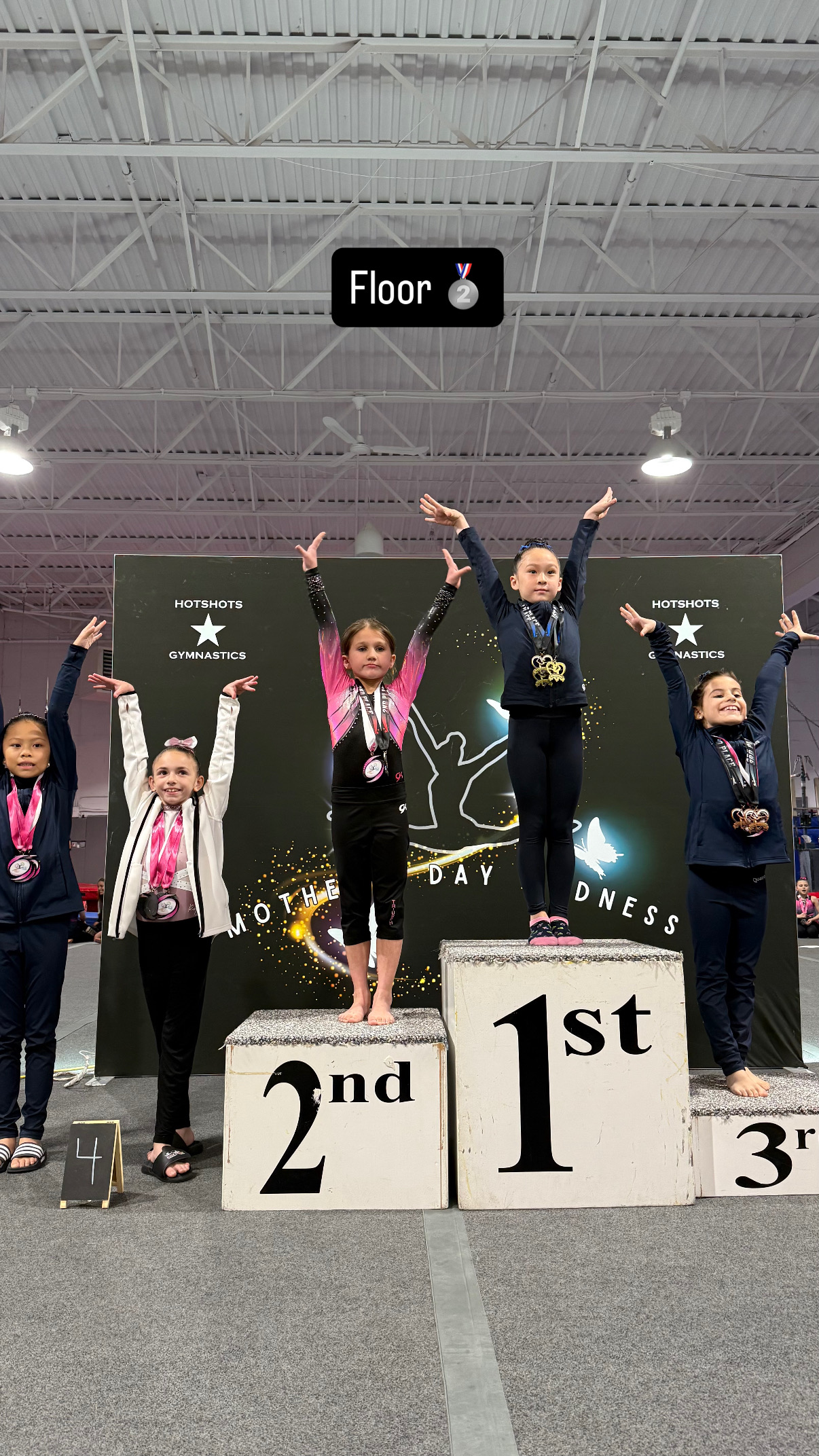 Team gymnasts posing with beach ball prop at competition