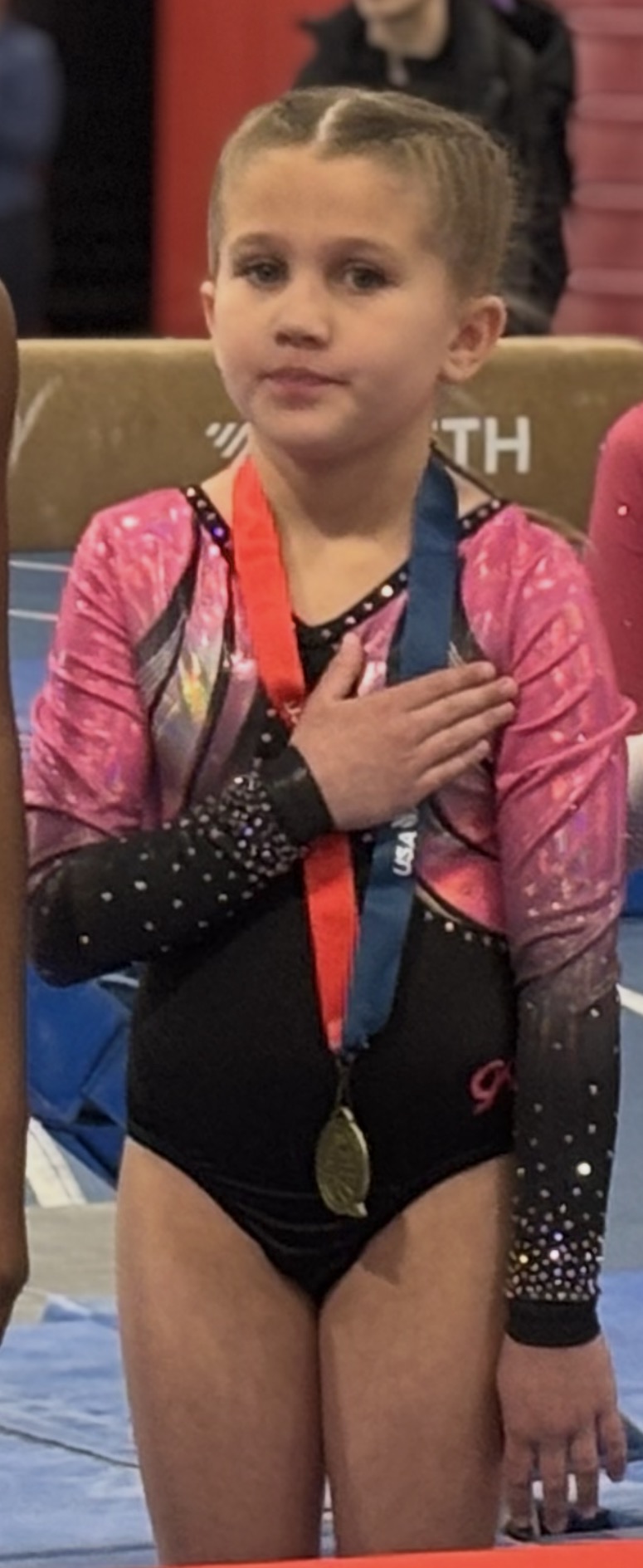 Competition awards ceremony with gymnasts on numbered stage